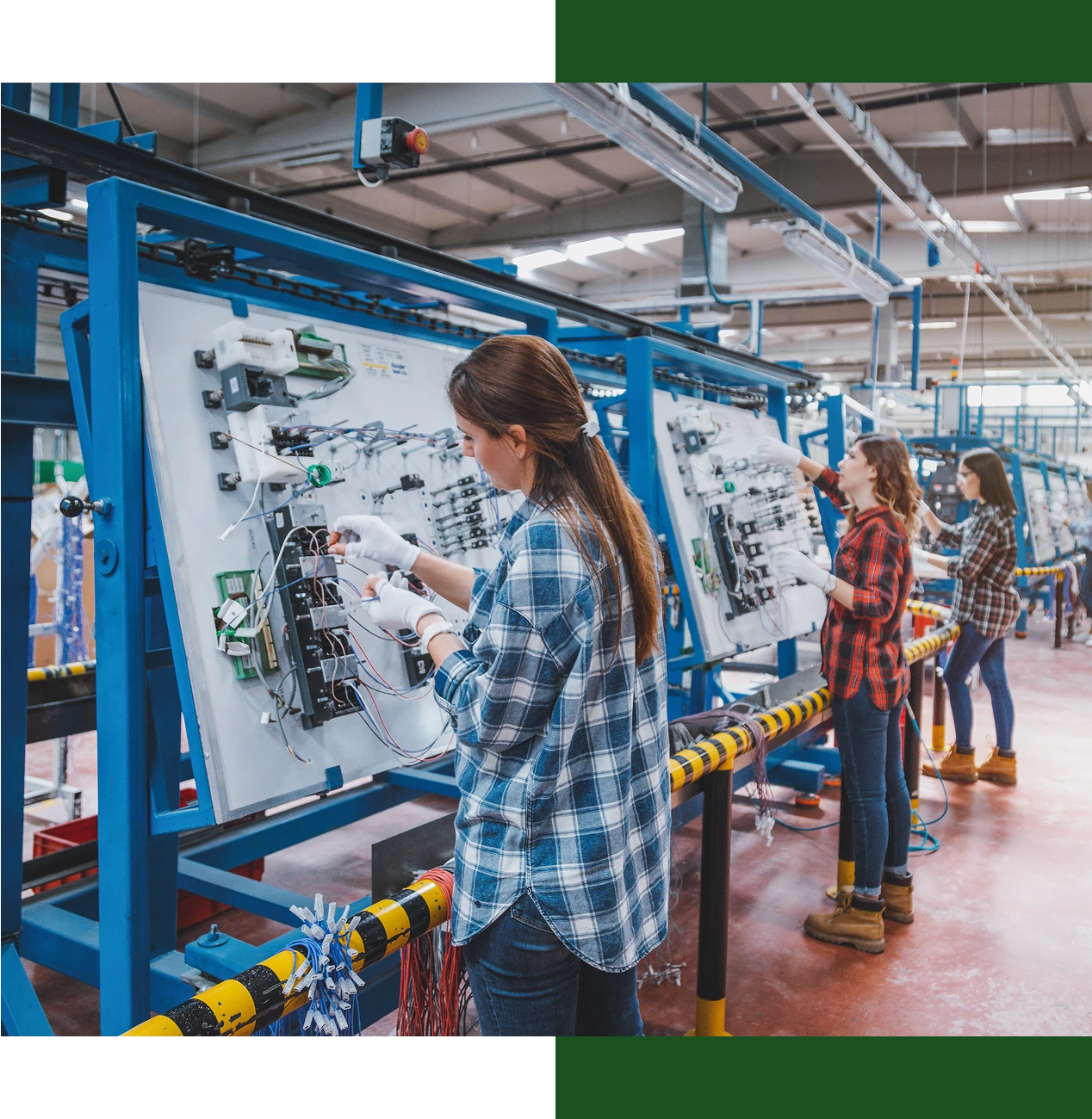 Women assembling electrical components in factory.