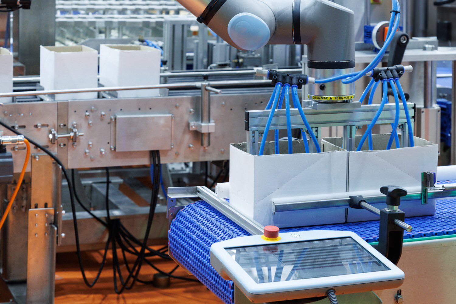 Robotic arm packaging boxes on conveyor belt.